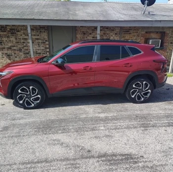 Side view of the red Chevrolet SUV photographed after detailing.