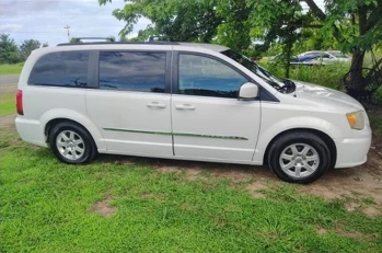 White minivan photographed from the side after detailing.